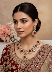 Woman wearing traditional jewelry and attire with a neutral background